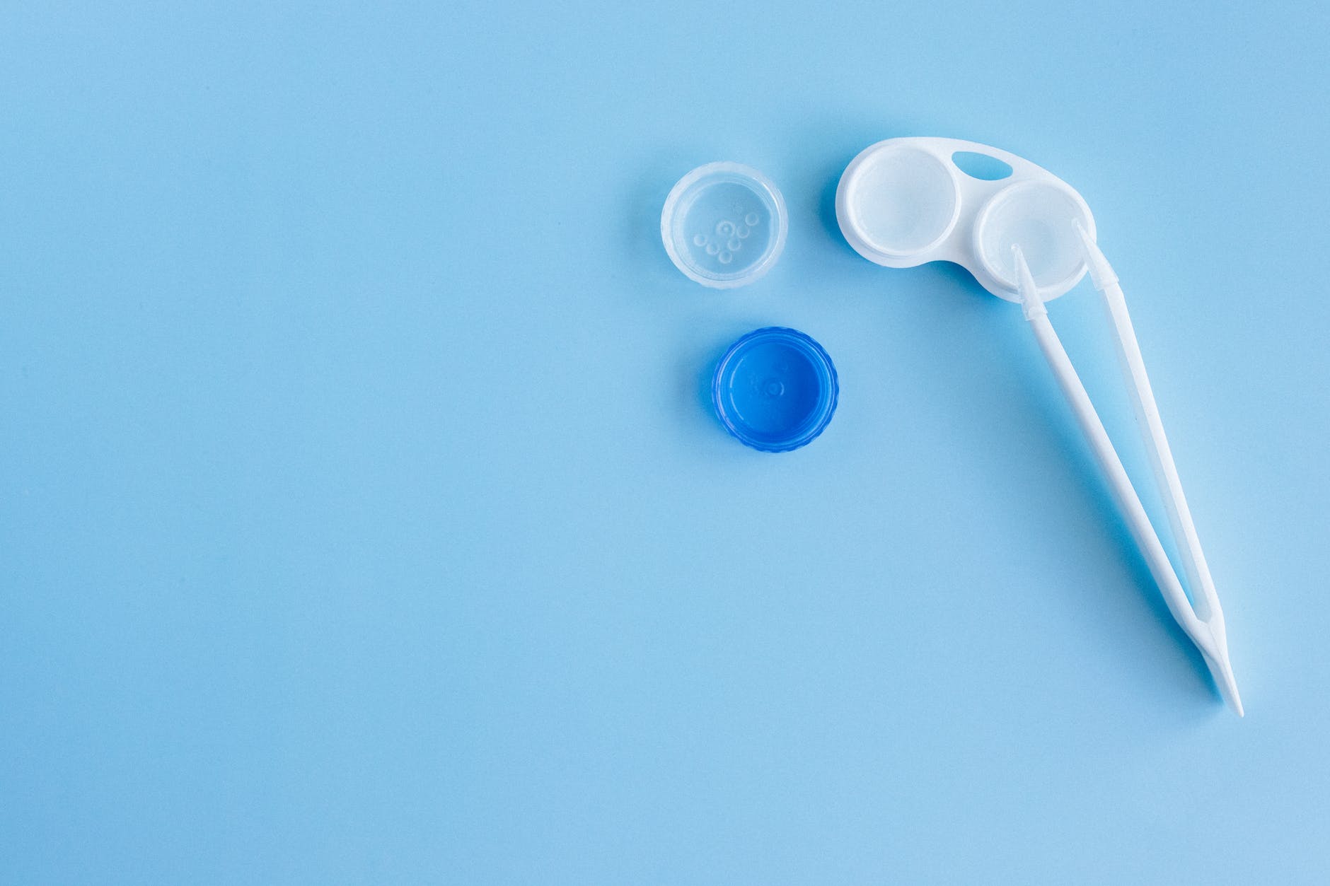 white and blue contact lens container on the blue table