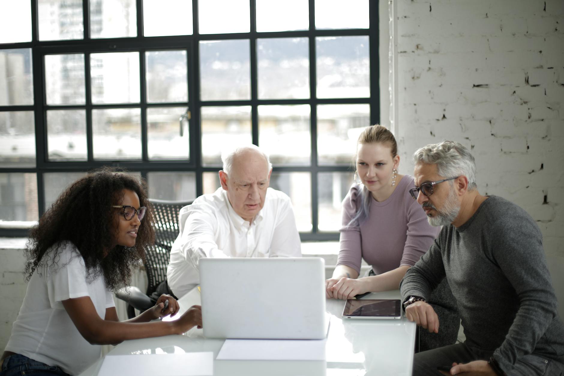 man in white long sleeved shirt presenting on a laptop